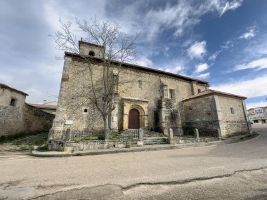 İspanya kırsalında çan kulesi ve Romanca kapısı olan ortaçağ taş kilisesi.