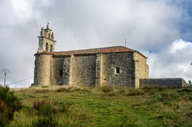 İspanya, Villacibio 'da çan gable ve eğimli çatısı olan tarihi taş kilise..