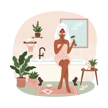 Havluya sarılmış bir kadın banyo paspası ve bitkilerle dolu bir banyoda otururken yeşim bir silindir kullanır ve sakin bir ortam yaratır..