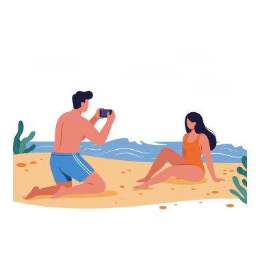 Adam, kumlu sahilde, okyanus dalgalarının yakınında oturan bir kadının fotoğrafını çekiyor..
