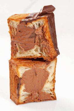 Dilimlenmiş taze kavrulmuş kübik kruvasan çikolatalı muhallebi dolgulu, jöleli ve siyah çikolata parçalı beyaz arka planda. Geleneksel tatlı viyana hamur işlerinin yaratıcı çeşitliliği