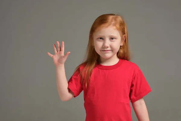 一个穿着红色T恤的小女孩露出了手势 五个手指 在灰色背景下被隔离开来 儿童的情感 — 图库照片