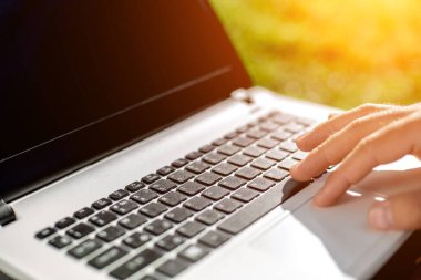 Yakın çekim yakışıklı kadeh dizüstü bilgisayar ekran dokunmadan eller mans. Dizüstü bilgisayar kullanan ve yerde oturan işadamı... Güneş parlaması