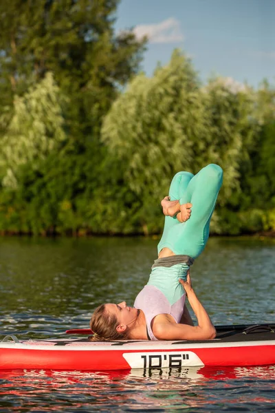 早上在桨板上练习瑜伽的女人 — 图库照片