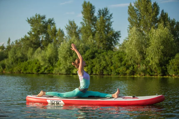 年轻女子用桨在船上做瑜伽 冥想姿势 侧面观点 与自然和谐相处的概念 自由健康的生活 自由职业 遥远的商业 — 图库照片