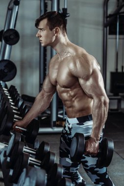 Spor salonunda egzersiz yapan güçlü kaslı vücut geliştirici. Fitness vücudunun bir parçası. Spor ve spor. Spor salonundaki fitness adamı. Fitness eğitimi