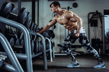 Spor salonunda egzersiz yapan güçlü kaslı vücut geliştirici. Fitness vücudunun bir parçası. Spor ve spor. Spor salonundaki fitness adamı. Fitness eğitimi
