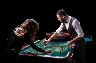 Bir tablo bir casinoda krupiye ve kadın oyuncu. Klasik casino rulet tekerleği resmi. Kumar. Kumarhane. Rulet. Poker