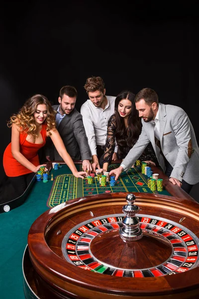Gruppe Junger Leute Hinter Roulettetisch Auf Schwarzem Hintergrund Junge Leute — Stockfoto