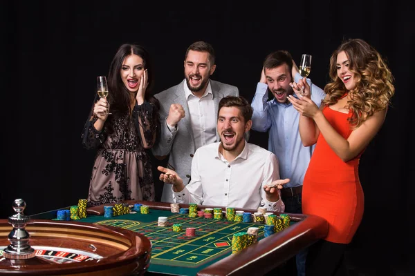 Gruppe Junger Leute Hinter Roulettetisch Auf Schwarzem Hintergrund Emotionaler Spieler — Stockfoto