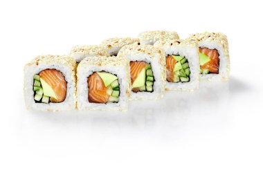 İştah açıcı California suşi rulolarına füme somon, avokado ve salatalık serpiştirilmiş beyaz arka planda susam tohumları. Japon otantik mutfağı