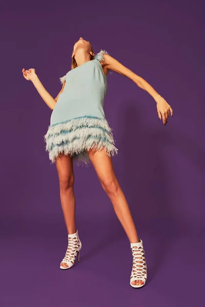 Studio Mor Arka Plan Üzerinde Dans Mavi Kokteyl Elbiseli Genç — Stok fotoğraf
