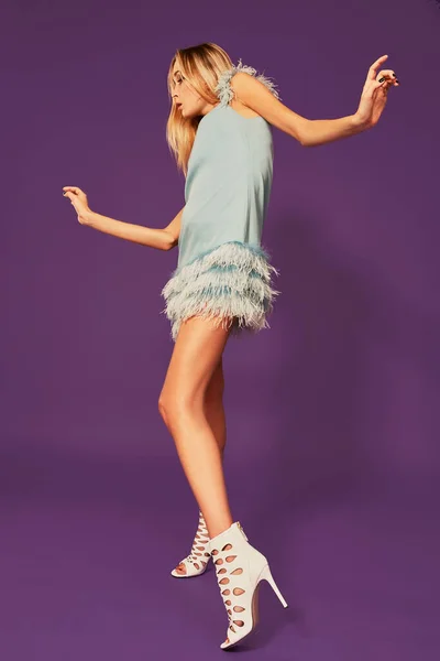 Studio Mor Arka Plan Üzerinde Dans Mavi Kokteyl Elbiseli Genç — Stok fotoğraf