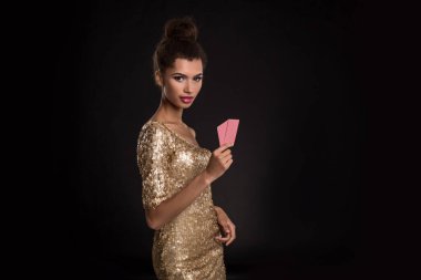 Güzel Afrikalı kız kumarhane pokerinde iki kart gösteriyor ve stüdyoda siyah arka planda genç bir kadın kazanıyor.