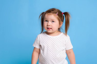 Mavi arka planda beyaz tişörtlü komik çocuk. Küçük güzel kız mesaj için uzayı kopyaladı. İndirim, doğum günü partisi konsepti.