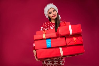 Yakın çekim birçok tutan hayran güzel kadın portresi, kamera, kırmızı zemin üzerine izole bakarak sunar. Noel. İndirimler. Dükkanlar. Satılık