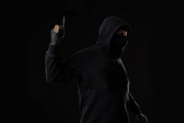Siyah arka planda baltası olan siyah maskeli bir haydut. Baltalı maskeli adam.