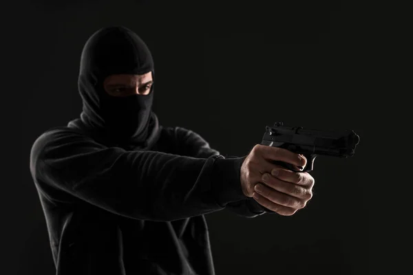 Maskeli Silahlı Soyguncu Siyah Bir Arka Planda Yan Tarafı Işaret — Stok fotoğraf