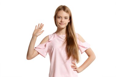 Studio portrait of a lovely blonde adolescent in a pink t-shirt isolated on white background in various poses. She expresses different emotions posing right in front of the camera, smiling and waving