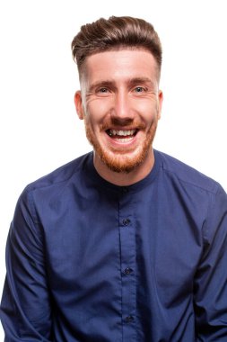 Attractive young bearded man wearing blue shirt is laughing, isolated over a white background.