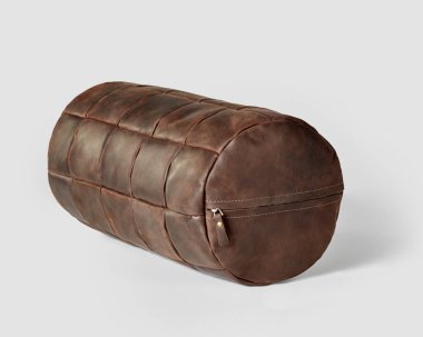 Decorative bolster cushion made of patches of tanned brown leather with zipper for stylish home interior design. Handmade genuine leather products