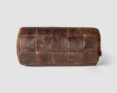 Ergonomically shaped brown genuine leather bolster cushion for decoration of living room sofa. Stylish hand-stitched natural products