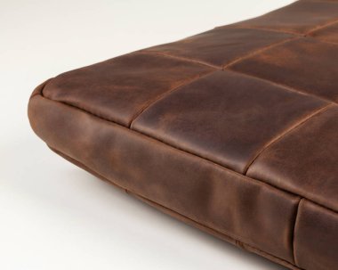 Closeup of functional brown leather seat cushion for comfortalbe rest on bench or floor. Stylish artisanal piece of furnishing