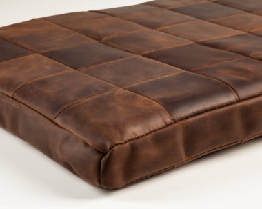 Hand-stitched floor mattress made of square pieces of brown genuine leather for comfortable rest. Handmade accessory for interior design