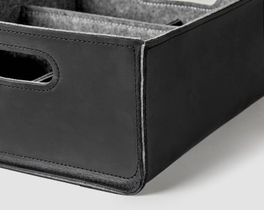 Closeup of black stitched genuine leather handicraft organizer lined with gray felt, made with internal dividers for easy storage and slotted handles for carrying. Home and office interior accessory