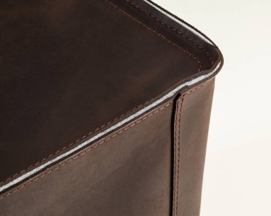 Close-up of walls of brown box made of genuine leather, thickened with layer of felt and neatly stitched with strong thread. Durable functional handcrafted organizer for storing home and office items