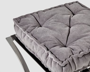 Closeup of soft puffy quilted gray velvet seat cushion in french style on metal ottoman. Handcrafted accessory for cozy home decor