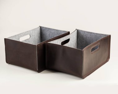 Two brown storage boxes made of genuine leather with gray felt inside. Stylish artisanal accessories to organize wardrobe or workplace