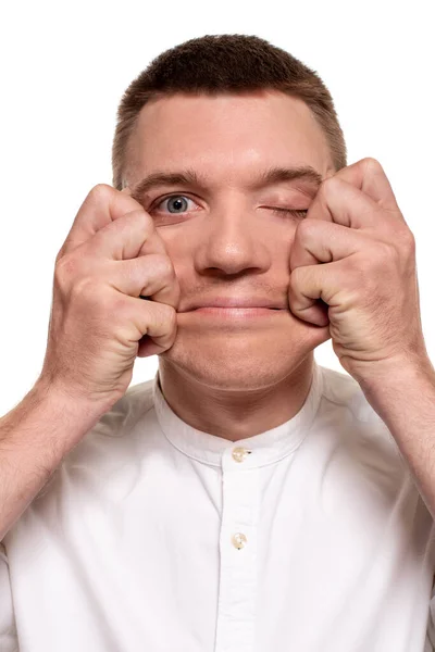 Okouzlující Mladý Muž Bílé Košili Dělá Obličeje Dotýká Jeho Obličeje — Stock fotografie