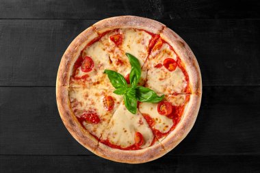 Pelati soslu, mozzarella peynirli, domatesli ve beyaz arka planda taze yeşil fesleğen yapraklı sulu Napoli pizza Margherita 'nın üst görüntüsü. Geleneksel İtalyan mutfağı