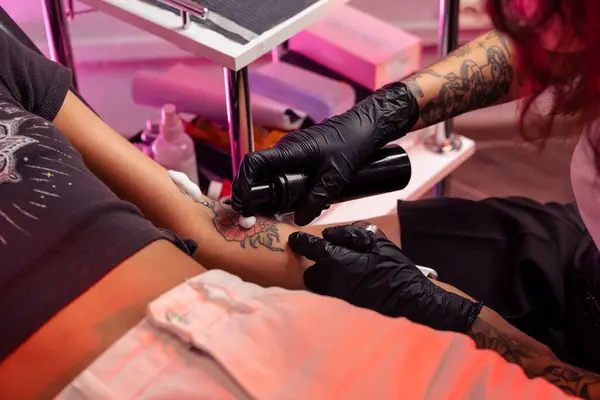 プロのスタジオタトゥーアーティストは 余分なインクや体液を除去するために女性の腕にカラフルな入れ墨花に石鹸抗菌フォームを塗布 クロップショット — ストック写真