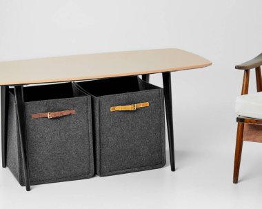 Masanın altında duran giysi ya da kitapların saklanması için kahverengi deri saplı gri renkli iki küçük kutu. El yapımı iç ögeler