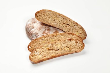 Buğday ekmeğinin tam ve dilimlenmiş somunları beyaz arka planda çıtır çıtır kahverengi kabuklu ve havadar desenli. Fırın ve ekmek yapma konsepti