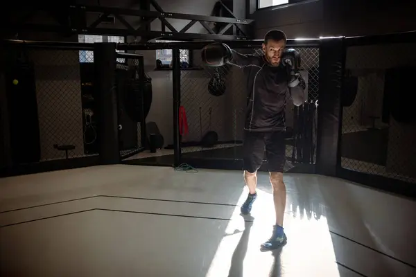 Motivated boxer honing striking skills with rigorous shadow fighting routine in modern training facility, showcasing discipline and technique