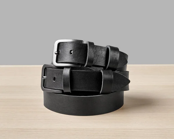 Zwei Gefaltete Schwarze Ledergürtel Mit Maßgeschneiderter Dad Prägung Auf Schlaufe lizenzfreie Stockbilder