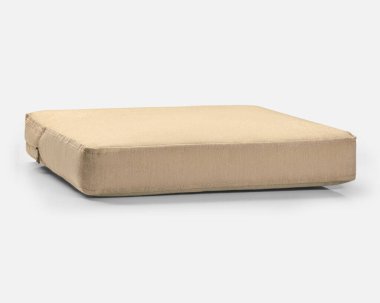 Kare bej yastık, beyaz bir yüzeyde görünen dikişler var.