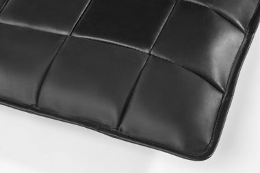 Siyah deri döşemeleri yakın plan kare şekiller oluşturuyor, mobilyalara zarafet katıyor.