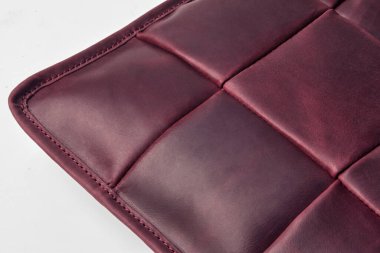 Burgundy deri yüzey yakın çekim görünür dikişler ve belirgin kare desen, zanaatkarlık ve kalite