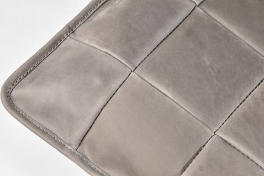 Gri deri yastık görünür dikiş ve doku ile, lüks ve rahat bir his yaratıyor.