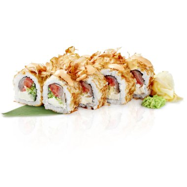 Ton balıklı suşi ruloları, sebzeler ve katsuobushi taneleri bambu bir yaprağın üzerinde sunuluyor ve görsel olarak çekici bir mutfak sahnesi yaratıyor.