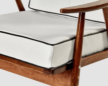 Ahşap çerçeveli modern beyaz deri koltuk rahat bir zarafet sergiliyor.