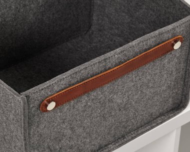 Boş gri keçeli bir kutuya yakın plan, kahverengi deri saplı, her yeri düzenlemek için mükemmel.