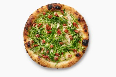Pesto, tavuk, roka, güneşte kurutulmuş domates ve beyaz arka planda izole edilmiş parmesan peynirli lezzetli pizza.