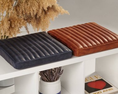 Kahverengi ve mavi deri koltuk minderleri çağdaş bir iç mekâna biraz zarafet katar.