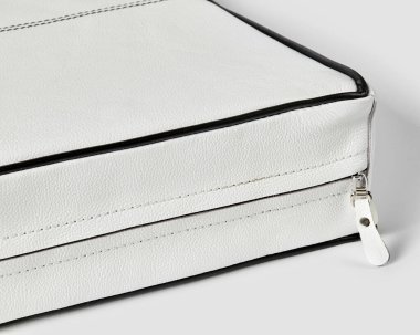 İçinde siyah borular ve güvenli bir fermuar kapağı olan şık beyaz deri bir çanta.