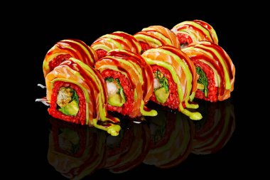 Somon, ton balığı, avokado ve wasabi mayonezli taze uramaki suşileri siyah arka plana yansıyor.